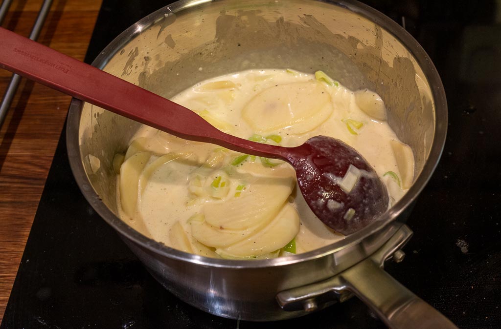 Ingredienserna till potatisgratängen kokas ihop