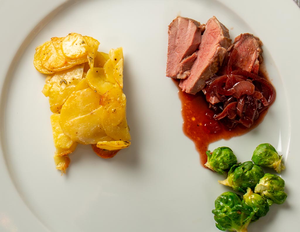 Gåsbröst med rödlökssky, potatisterrin och brysselkål
